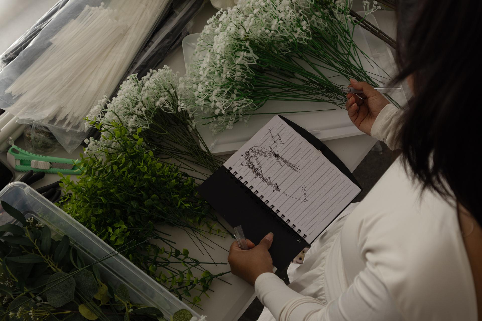 Florist creating wedding bouquet following sketch instructions
